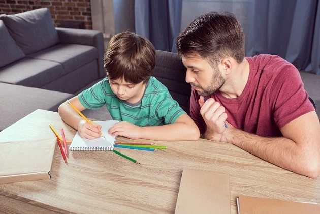 Father helping son with schoolwork